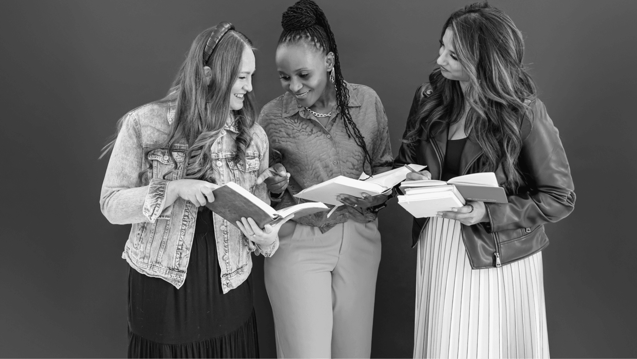 A grayscale image of three women talking with opened Bibles.